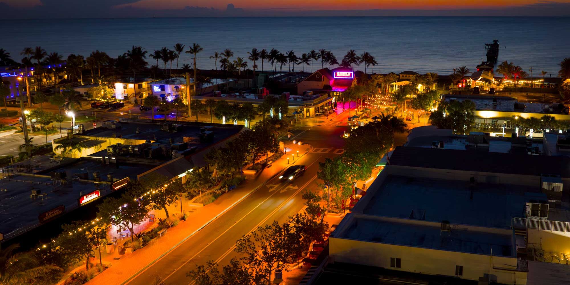 Orange turtle-safe lighting shines after dark in a coastal neighborhood