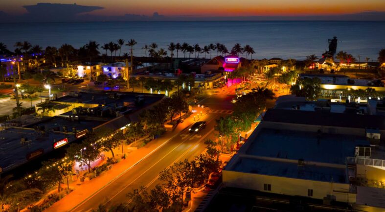 Orange turtle-safe lighting shines after dark in a coastal neighborhood
